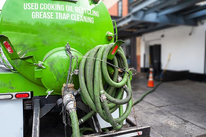 a professional technician pumping a restaurant's grease trap in Addison IL